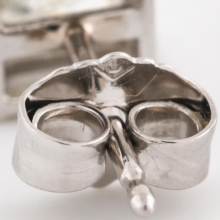 A pair of princess cut diamond earrings.