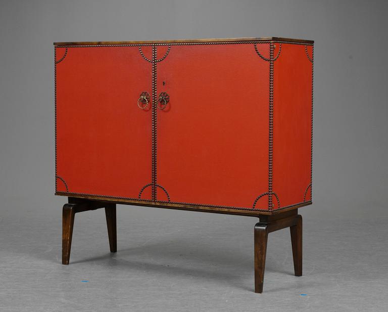 An Otto Schulz cabinet on stand with artificial red leather and brass details on a stained oak and birch stand, by Boet, Gothenburg, probably 1950's.