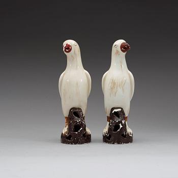 A pair of white andred glazed figures of parrots, late Qing dynasty.