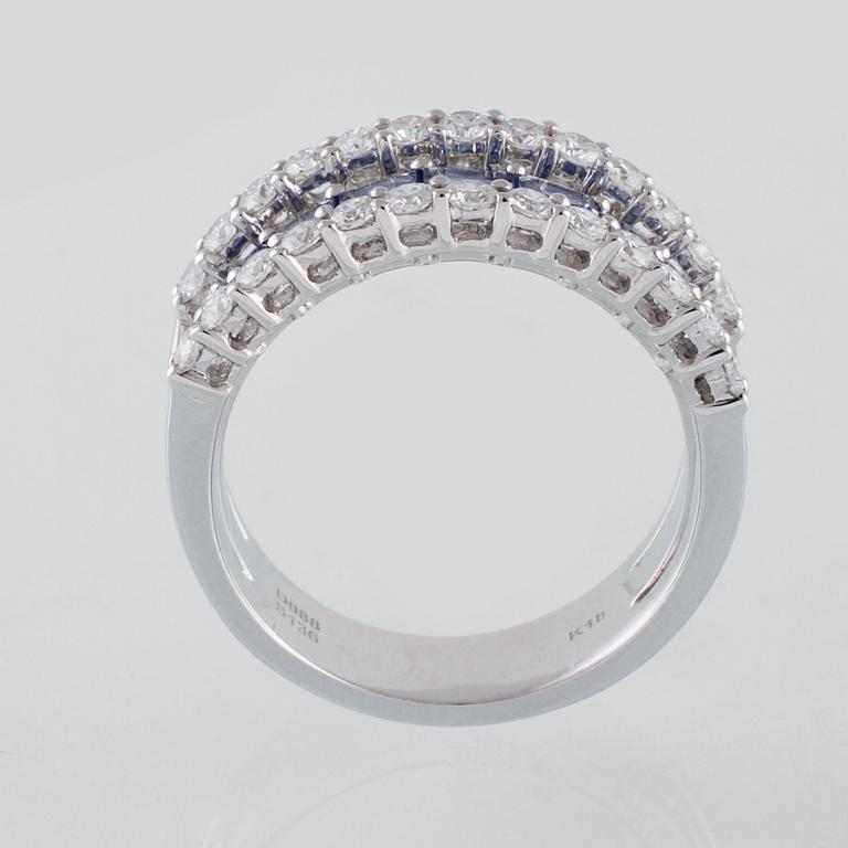 RING, 18K vitguld med 26 briljantslipade diamanter 0.88 ct samt 7 blå safirer 1.36 ct. Vikt 7,8 gram.