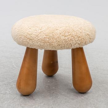A contemporary stool with birch legs and new sheepskin upholstery.
