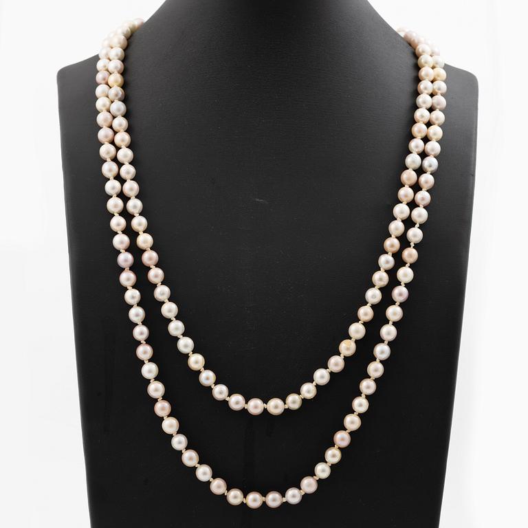 Long cultured pearl necklace with an 18K white gold clasp set with emeralds.