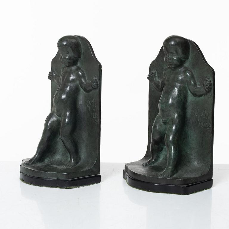 Axel Gute, a pair of patinated bronze bookends, dated 1920.