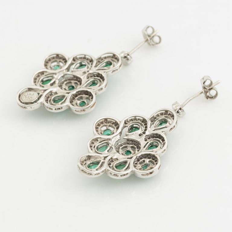 Earrings, a pair, and a pendant in white gold with emeralds and brilliant-cut diamonds.