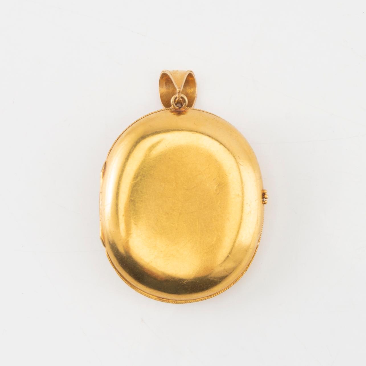 A 14K gold medallion with carved shell cameo.