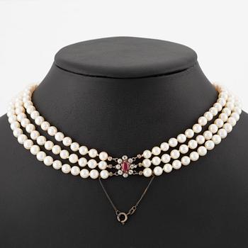 Pärlcollier, treradigt, med doserade odlade pärlor, guld med gammalslipade diamanter och syntetisk rubin.