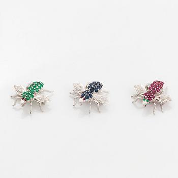 Tre broscher 18K vitguld med runda briljantslipade diamanter samt rubiner, safirer och smaragder.
