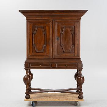 A stained pine Baroque cabinet, on a later stand. From around the year 1700.