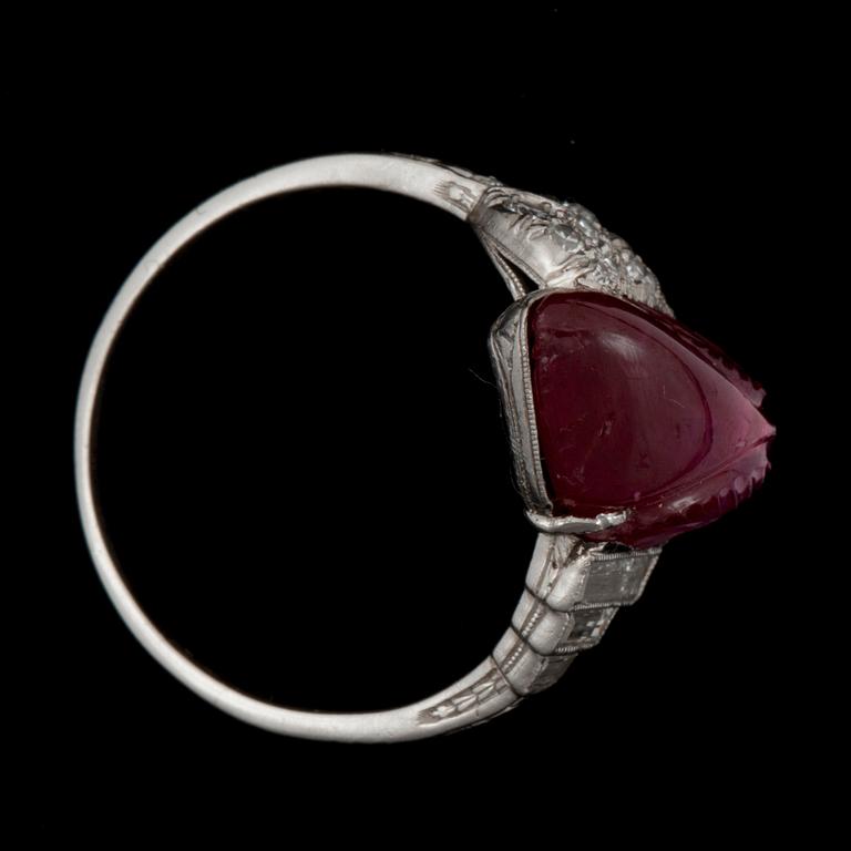 A carved untreated Burmese ruby 6.02 cts and diamond ring. Total carat weight of diamonds circa 0.30 ct.