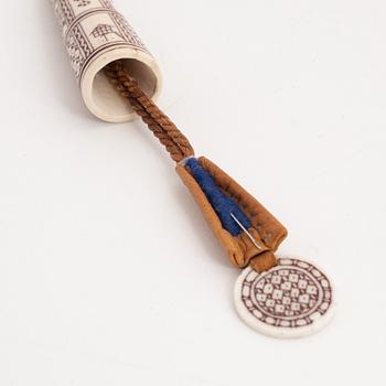 An engraved reindeer needle case.