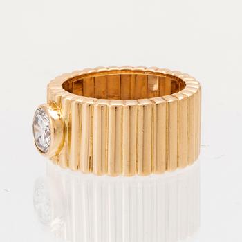 An 18K gold solitaire ring with a round brilliant-cut diamond.