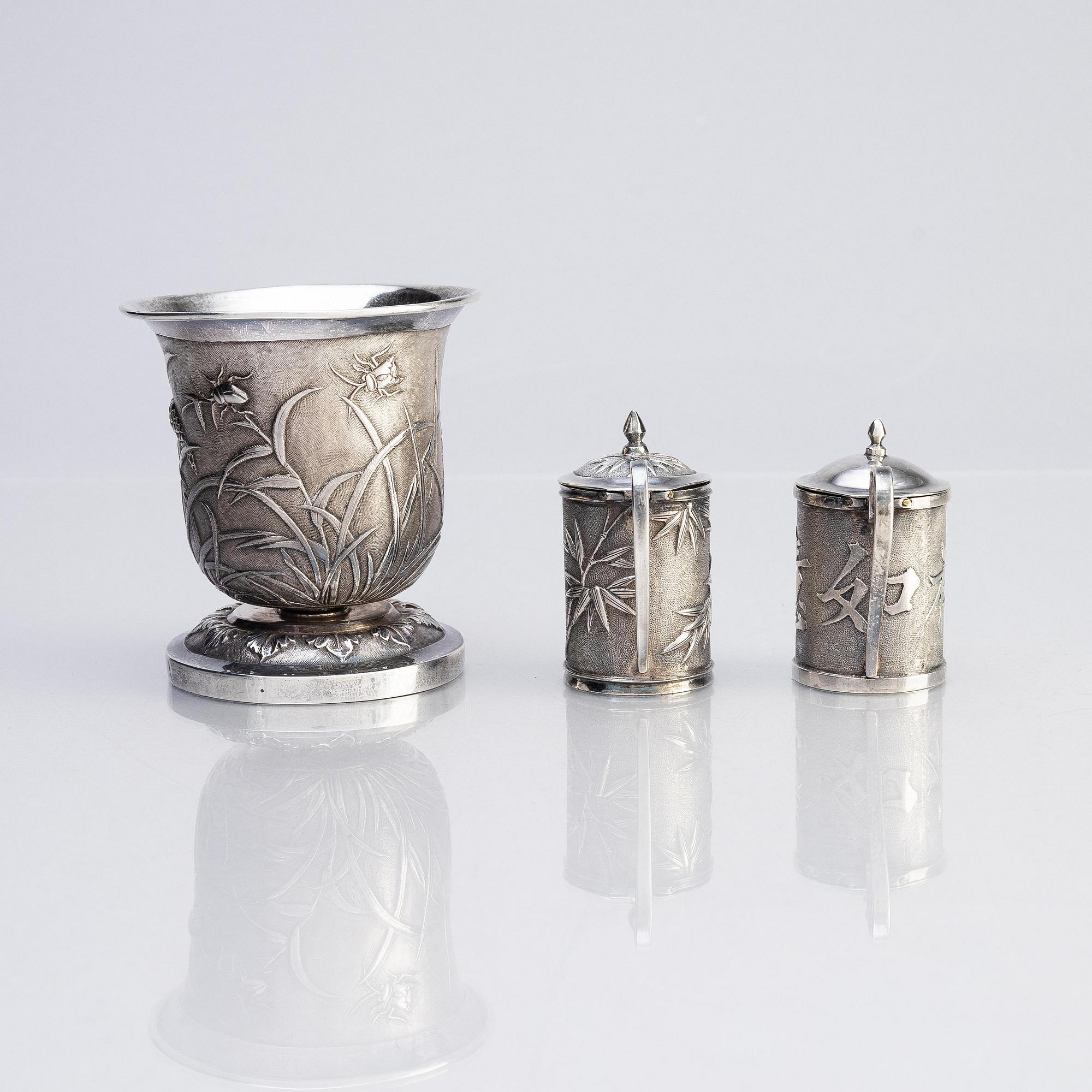 A Chinese Export silver beaker and two silver mustard pots, early 20th century.