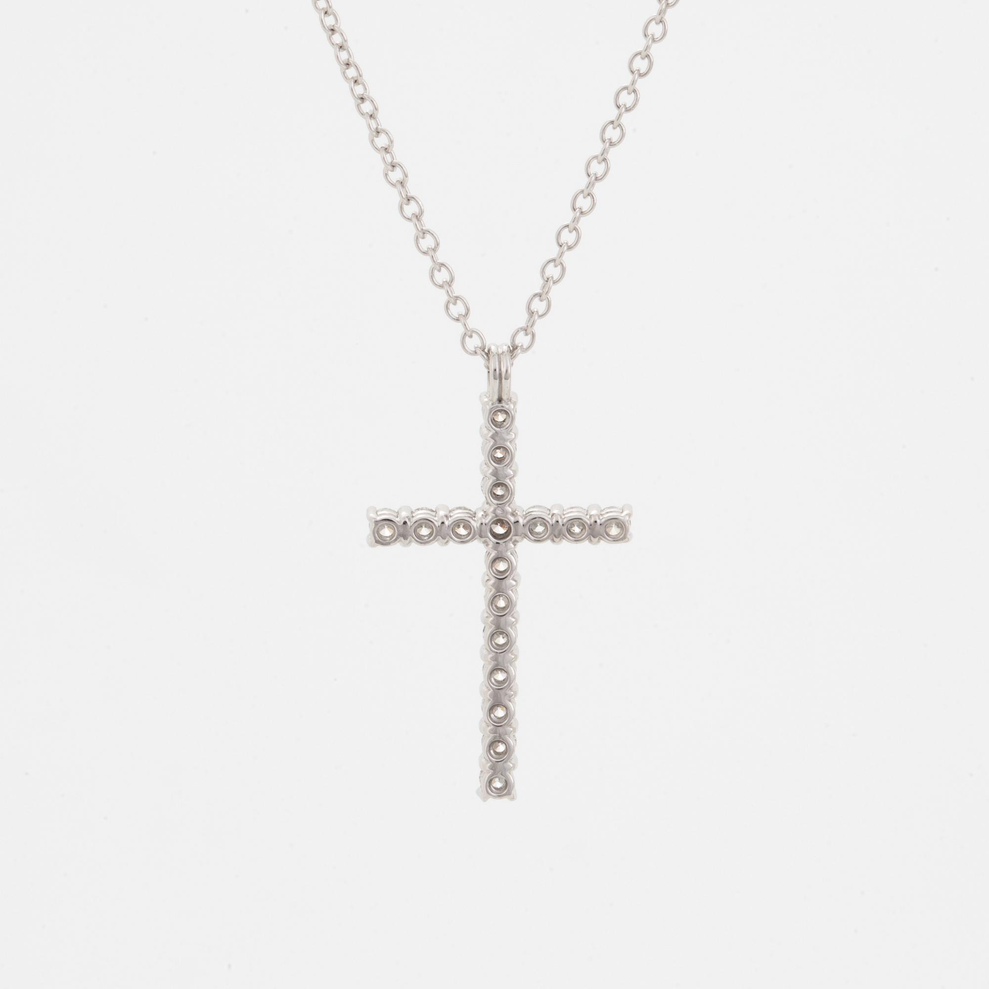 Brilliant-cut diamond cross pendant.