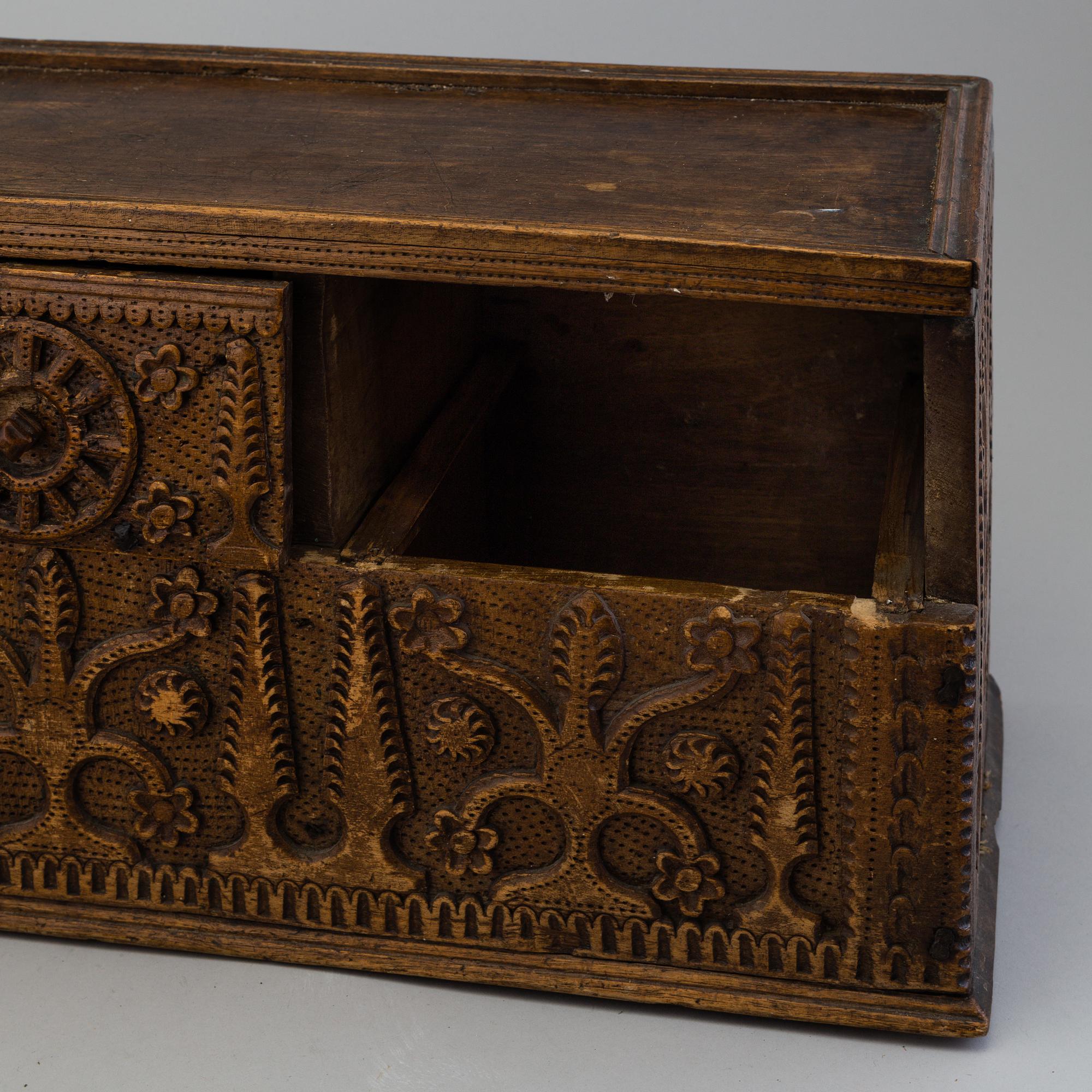 A 19th century wooden box with drawers.