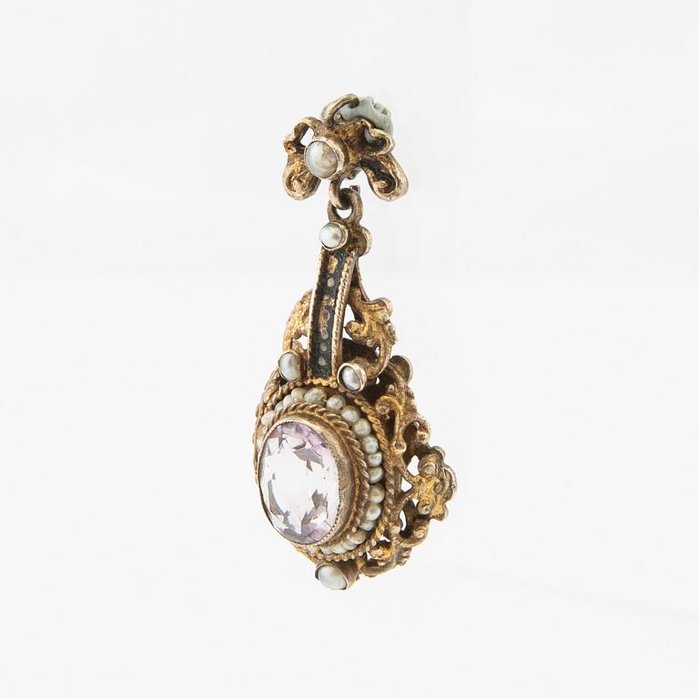 Pendant of gilded silver with an oval faceted amethyst, seed pearls, and enamel decoration, late 19th century.