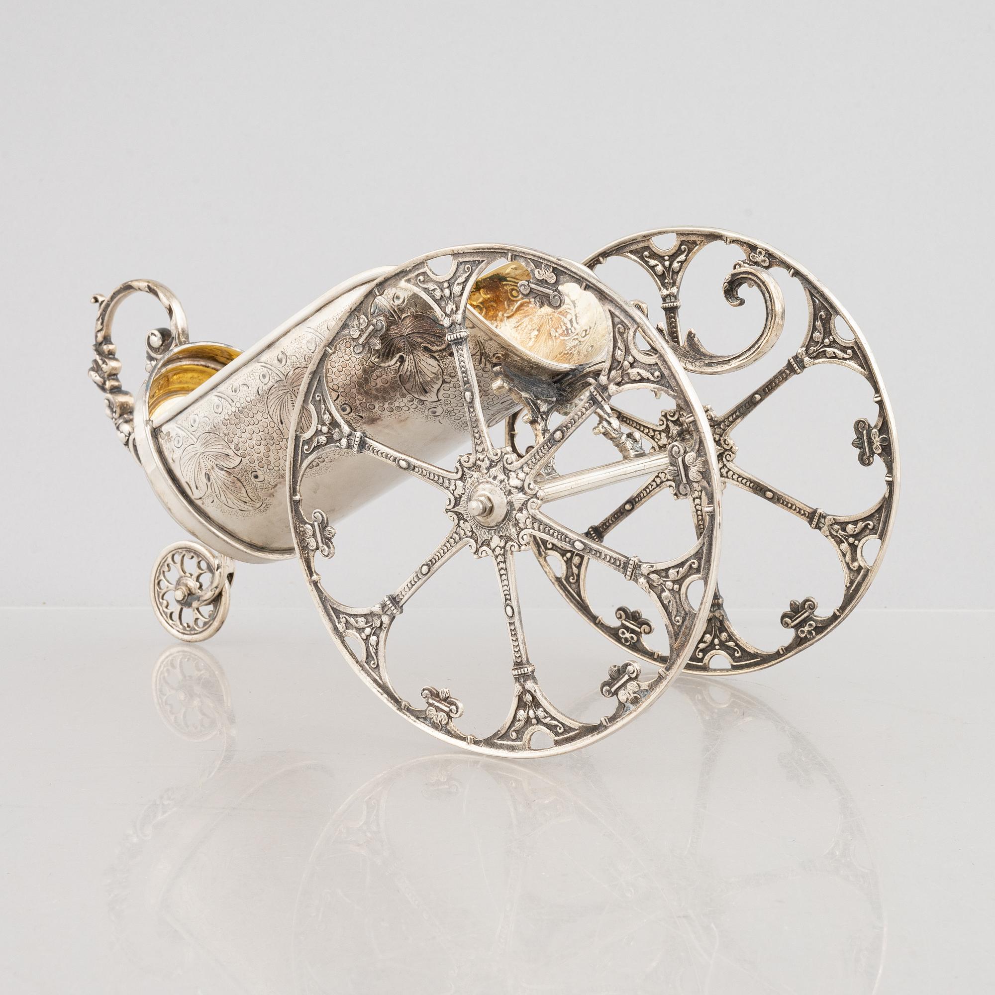 A silver bottle holder with wheels, 20th Century.