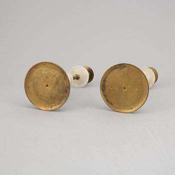 An alabaster mantle clock and pair of candlesticks, circa 1900.