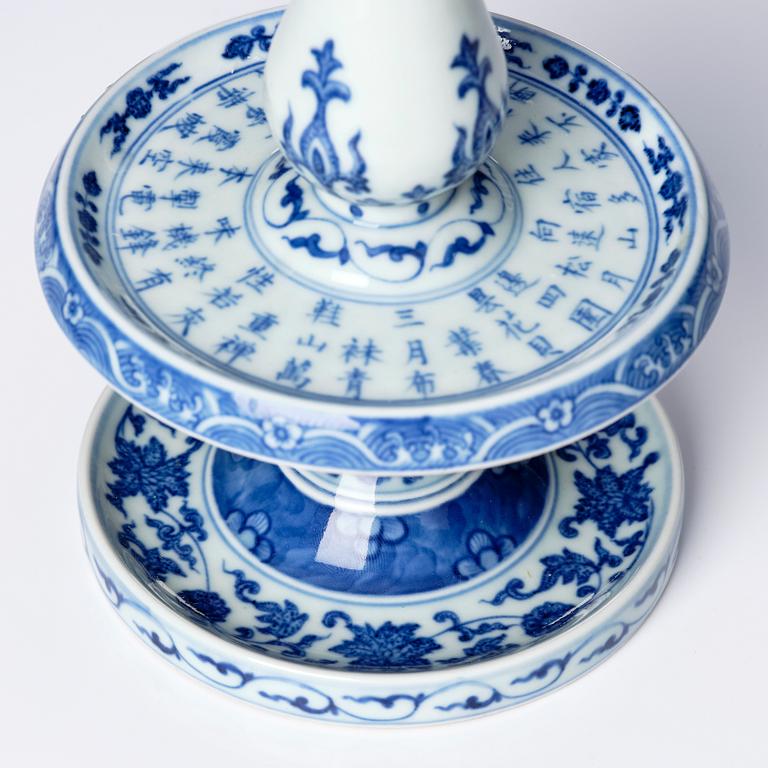 A pair of blue and white pricket candle sticks, with a poem, Qing dynasty with a Qianlong mark and of the period.