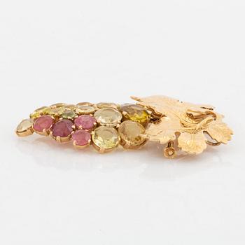 A brooch and a pair of earrings in 18K gold set with tourmalines and garnets.