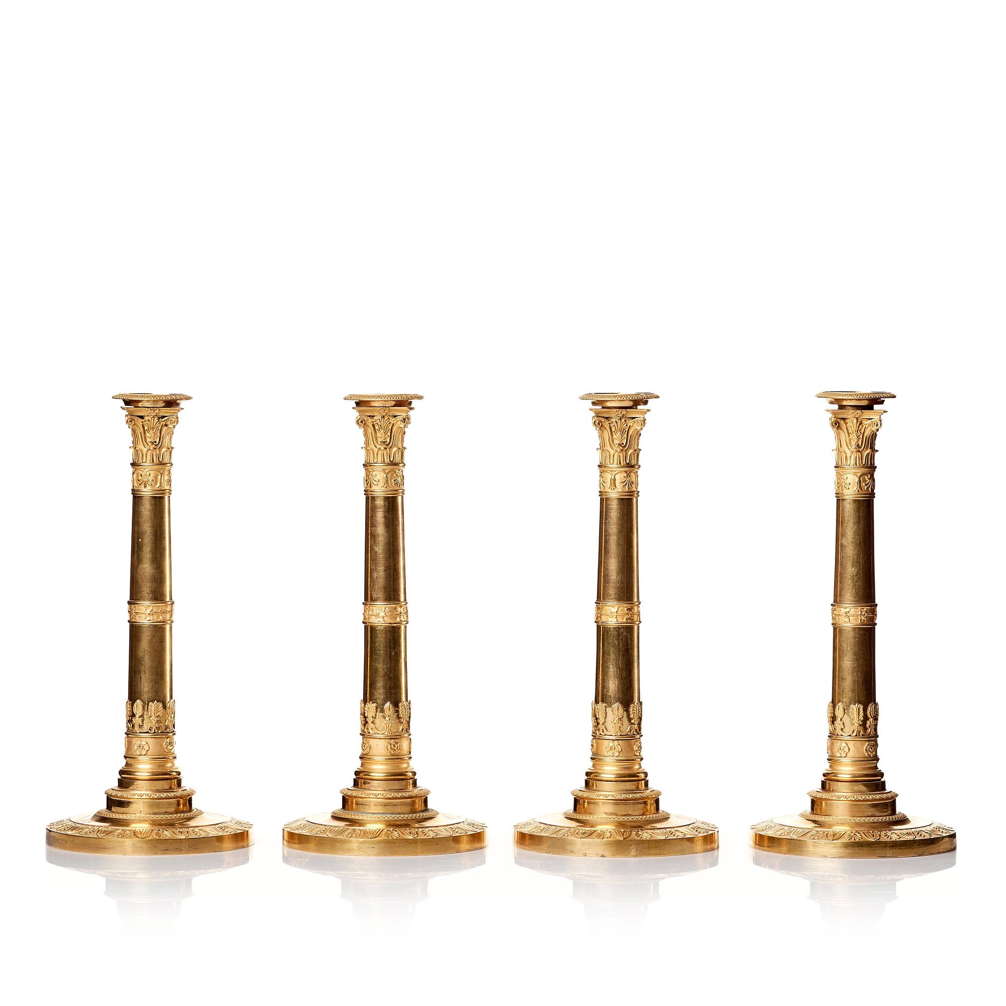 A set of four Empire presumably Russian candlesticks in gilded bronze.