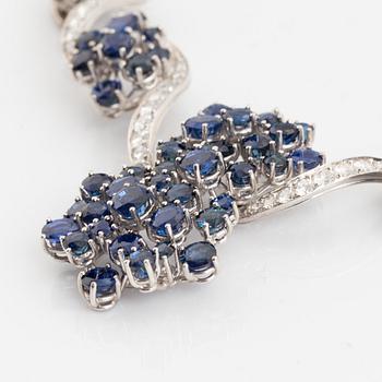 An 18K white gold necklace set with round brilliant-cut diamonds and sapphires.