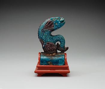 A turquoise and purple glazed roof top tile in the shape of a fish, Ming dynasty.