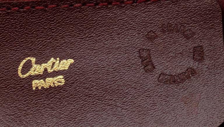 A bordeaux coloured leather weekendbag by Cartier.