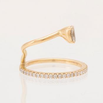 An 18K gold ring set with an oval cut and round brilliant cut diamonds by LWL Jewelry.