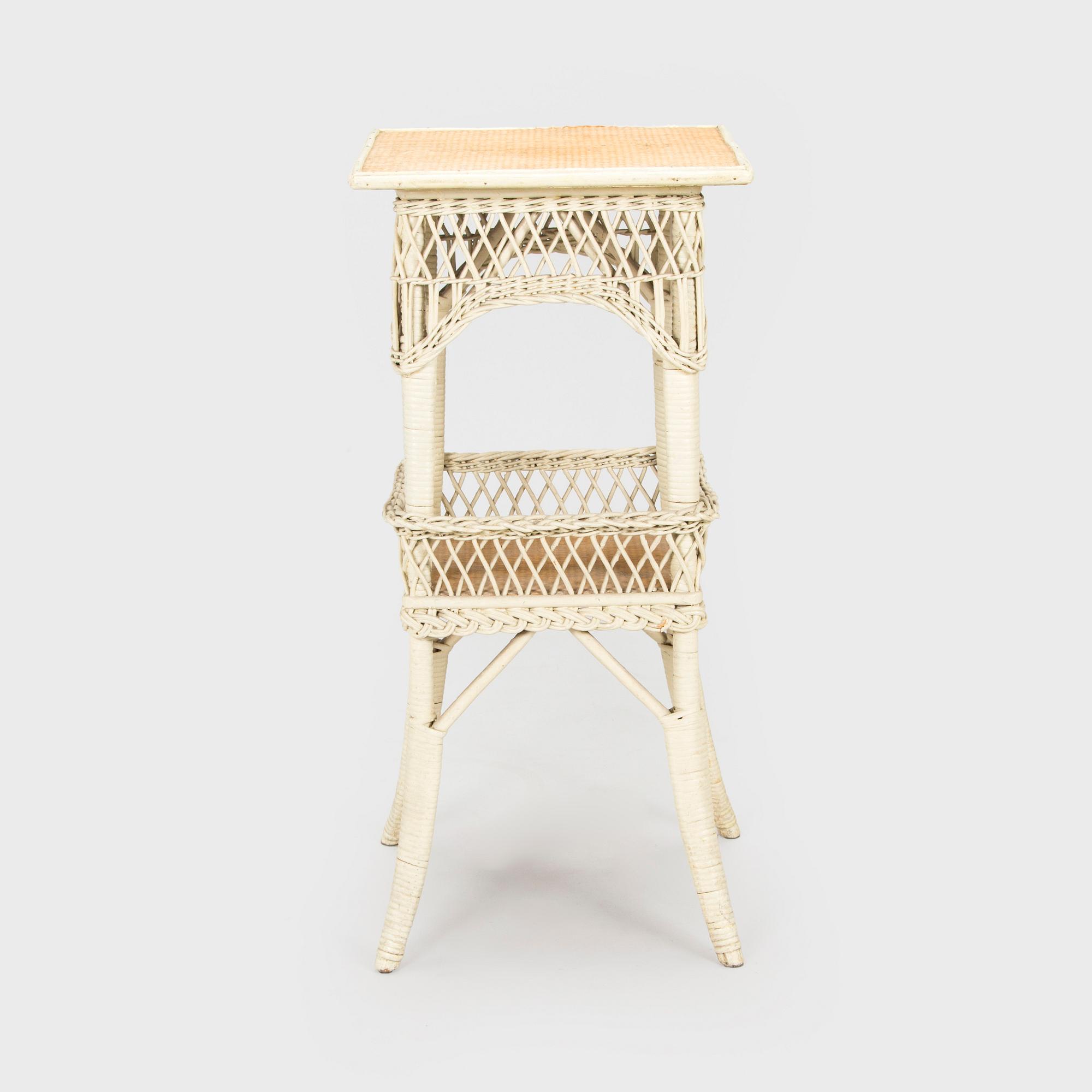 A mid-20th-century three-piece rattan furniture set including two armchairs, and a table.