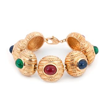 CHRISTIAN DIOR, a gold colored metall braclet with decorative glass stones.