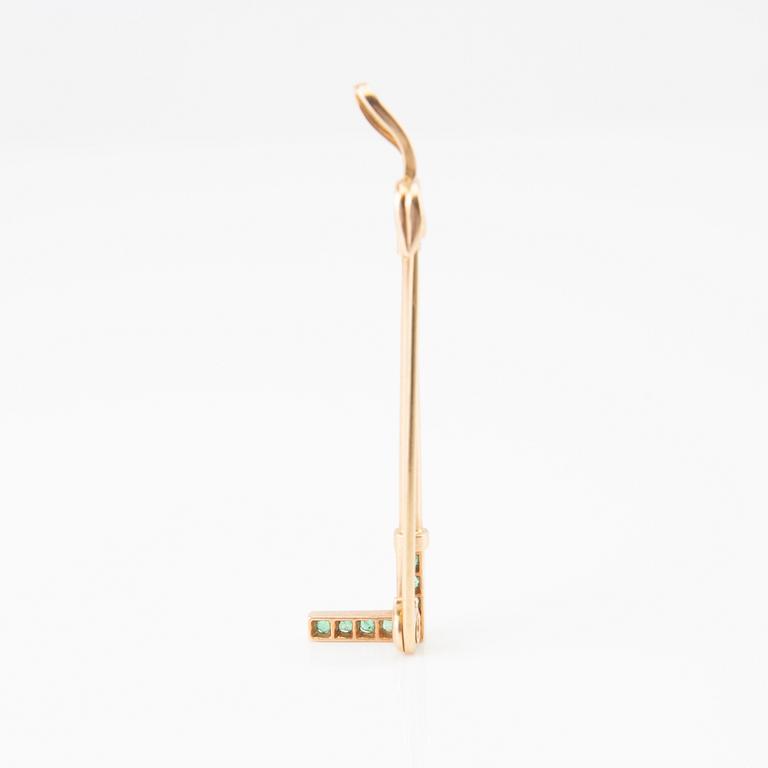 Brooch in the shape of a riding crop, 8K gold with faceted emeralds and rose-cut diamonds.