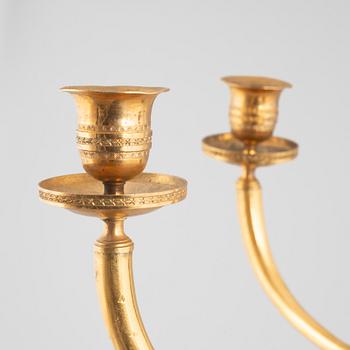 A pair of Empire-style two-branch patinated and gilt bronze appliques, 20th century incorporating older elements.