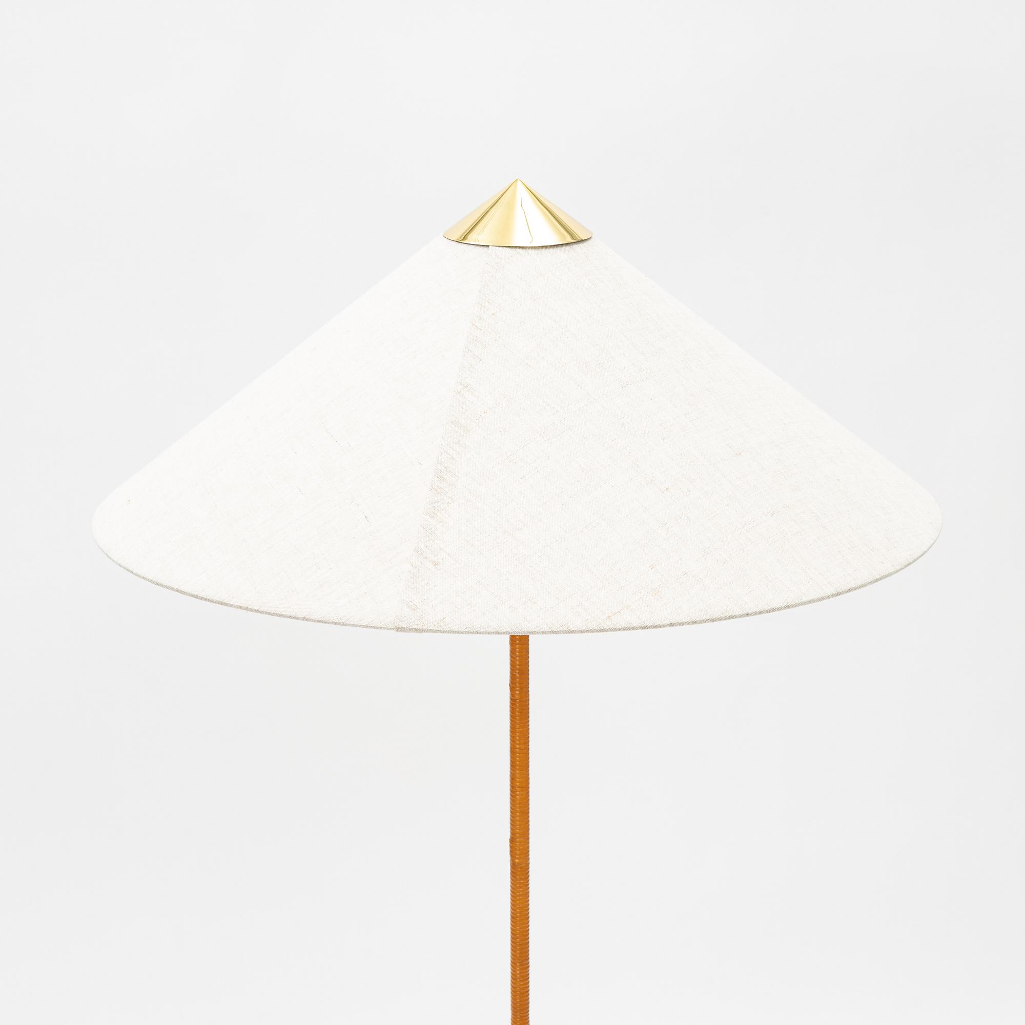 Paavo Tynell, A model 9602 brass and rattan floor lamp with canvas shade from Gubi,