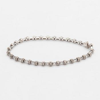 An 18K white gold bracelet set with baguette and brilliant-cut diamonds.