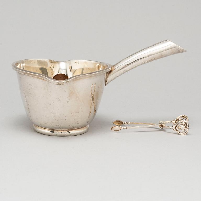 A Mexican sterling silver sauce pan and a Georg Jensen sugartangs, 20th century.