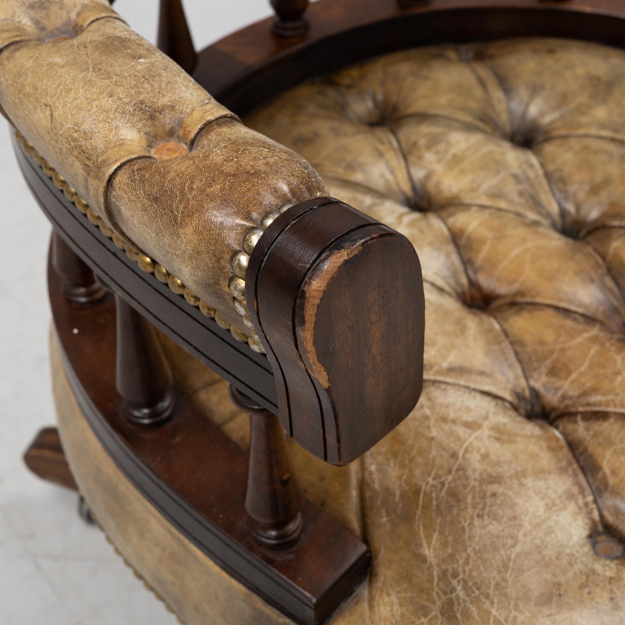 A 20th Century English mahogany and leather desk chair by Hillcrest Chair Actions.
