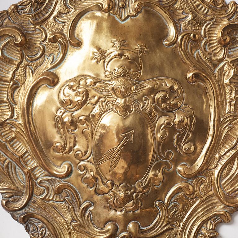 A pair of North European Rococo two-branch repoussé brass reflector plates, mid 18th century.