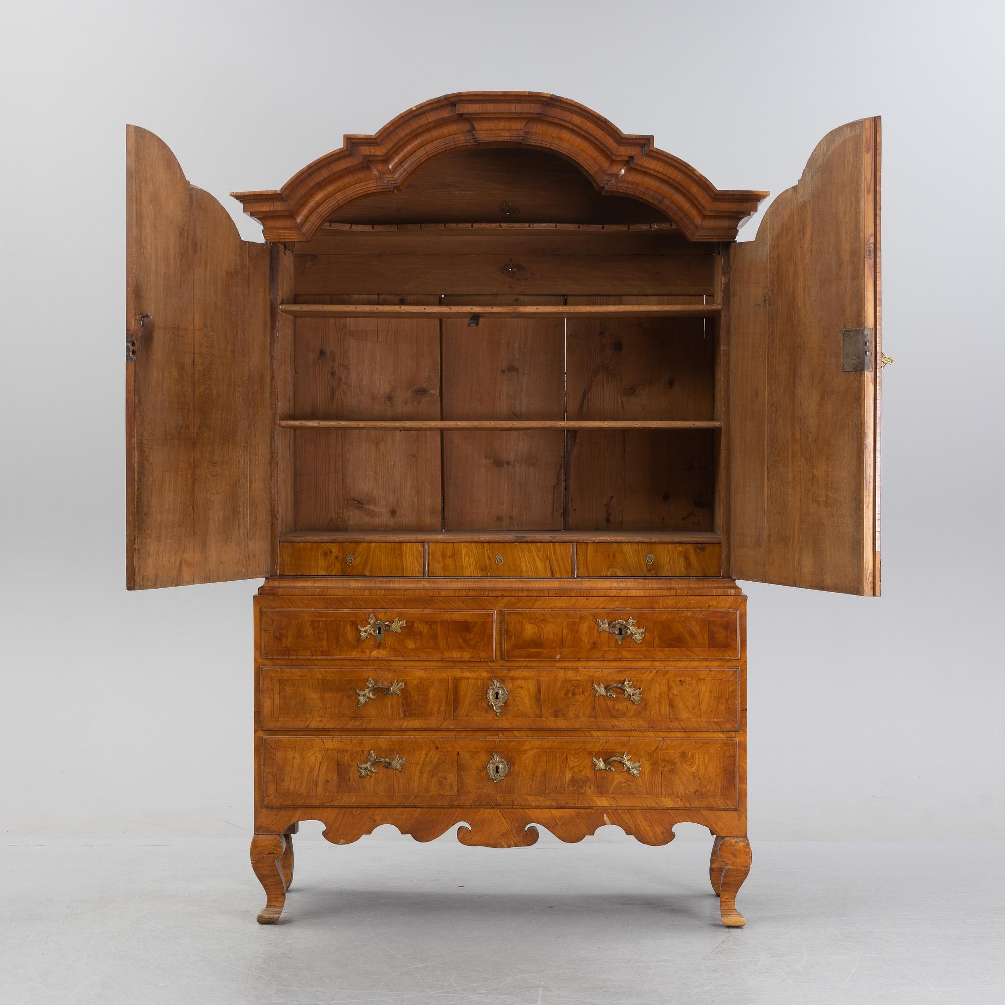 A walnut-veneered rococo cabinet in the manner of C. Linning, later part of the 18th Century.