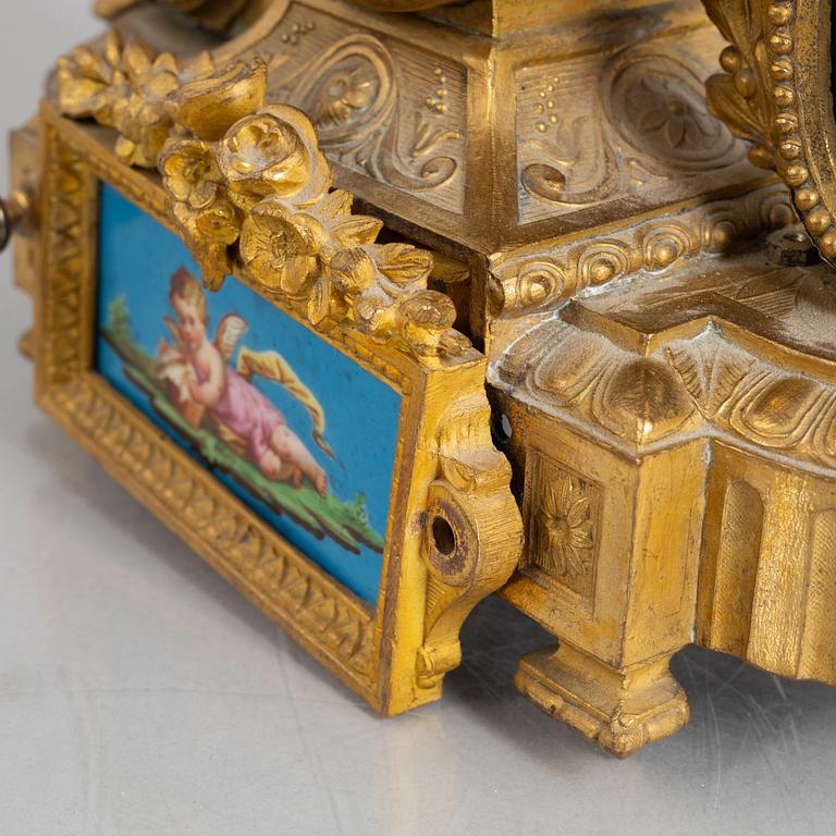 A Louis XVI style mantel clock and a pair of candelabra, circa 1900.