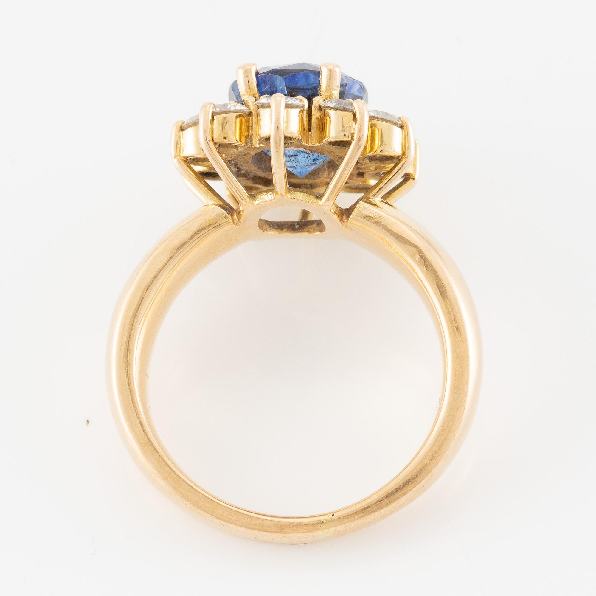 Ring 18K guld med en fasettslipad safir och runda briljantslipade diamanter.