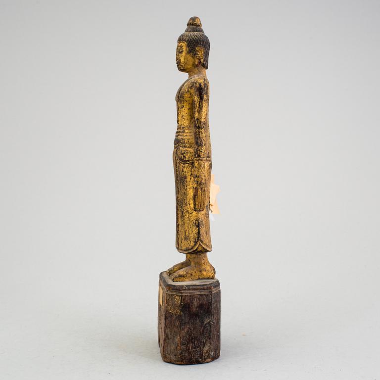 A Burmese sculpture of a standing buddha, circa 1900.