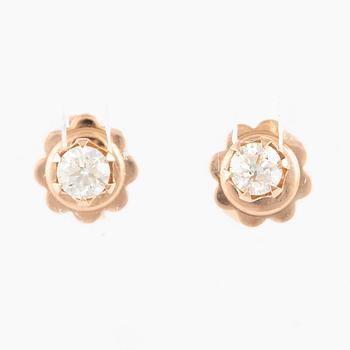 A pair of 14K gold earrings with round brilliant-cut diamonds.