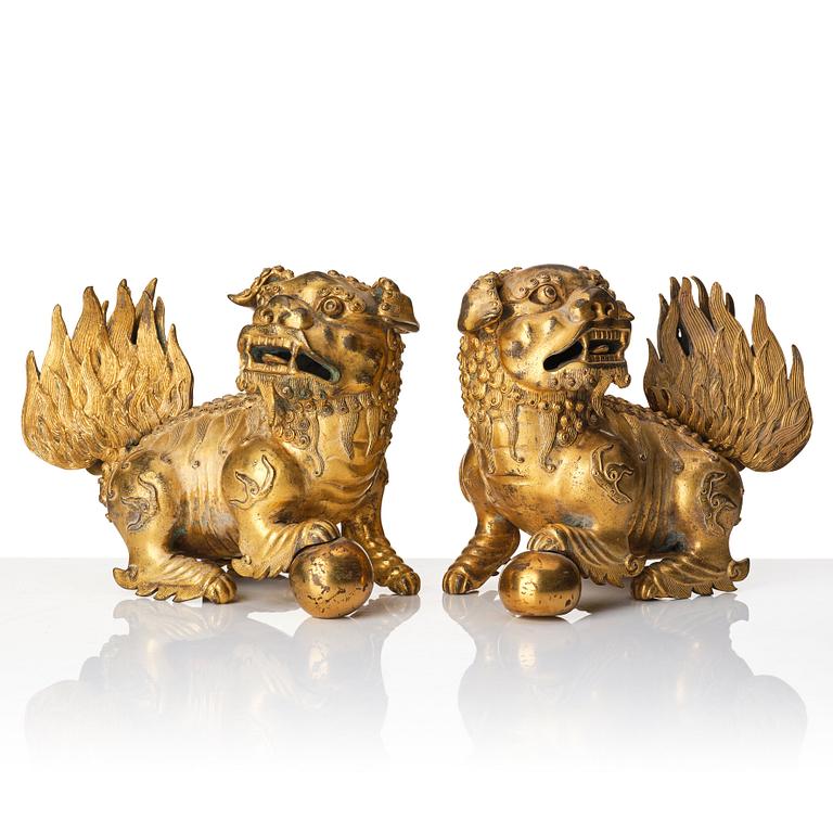 A pair of gilt bronze scultpures of buddhist lions, 18/19th Century.