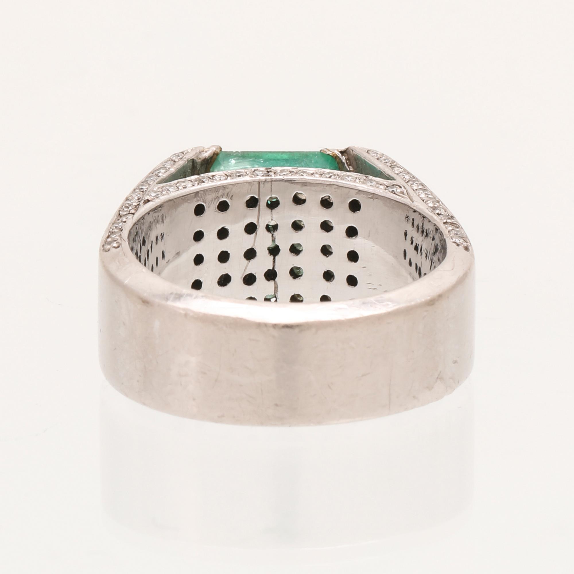A 9K white gold ring with an emerald and brilliant cut diamonds.