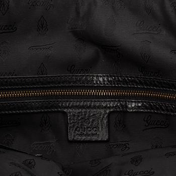 Gucci, a black leather handbag.