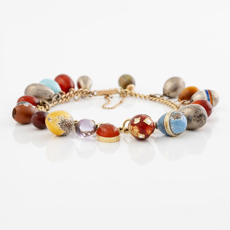 Bracelet with charms in the shape of eggs, the bracelet is 14K gold and 13 loose charms in the shape of eggs.