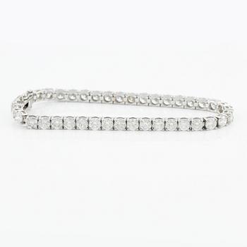 An 18K gold tennis bracelet with round brilliant-cut diamonds.