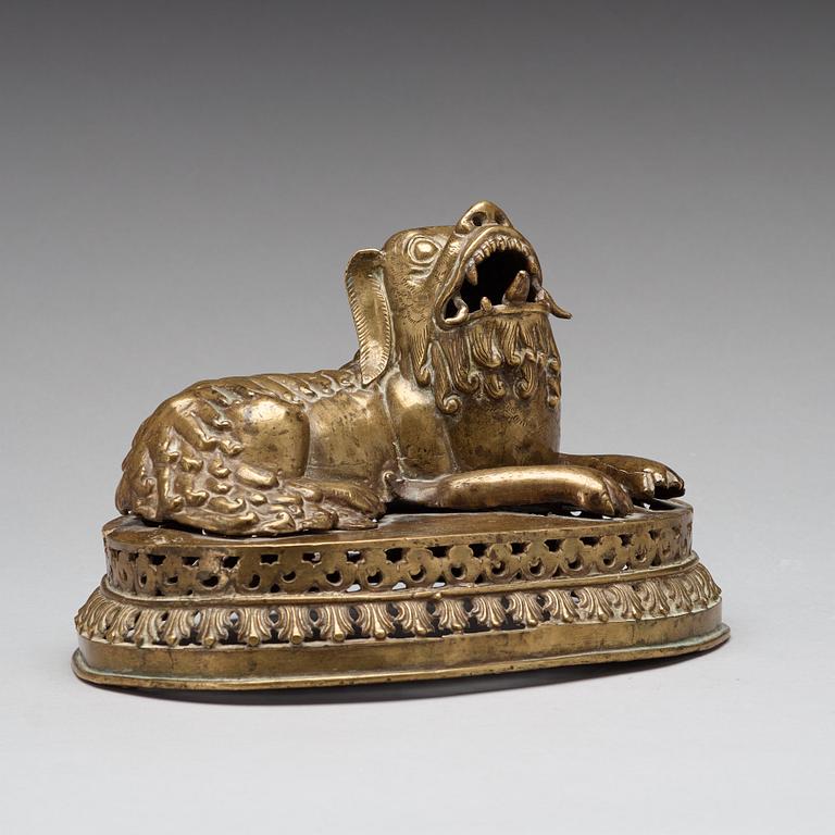 A copper alloy figure of a reclining buddhist lion, presumably 18th Century.