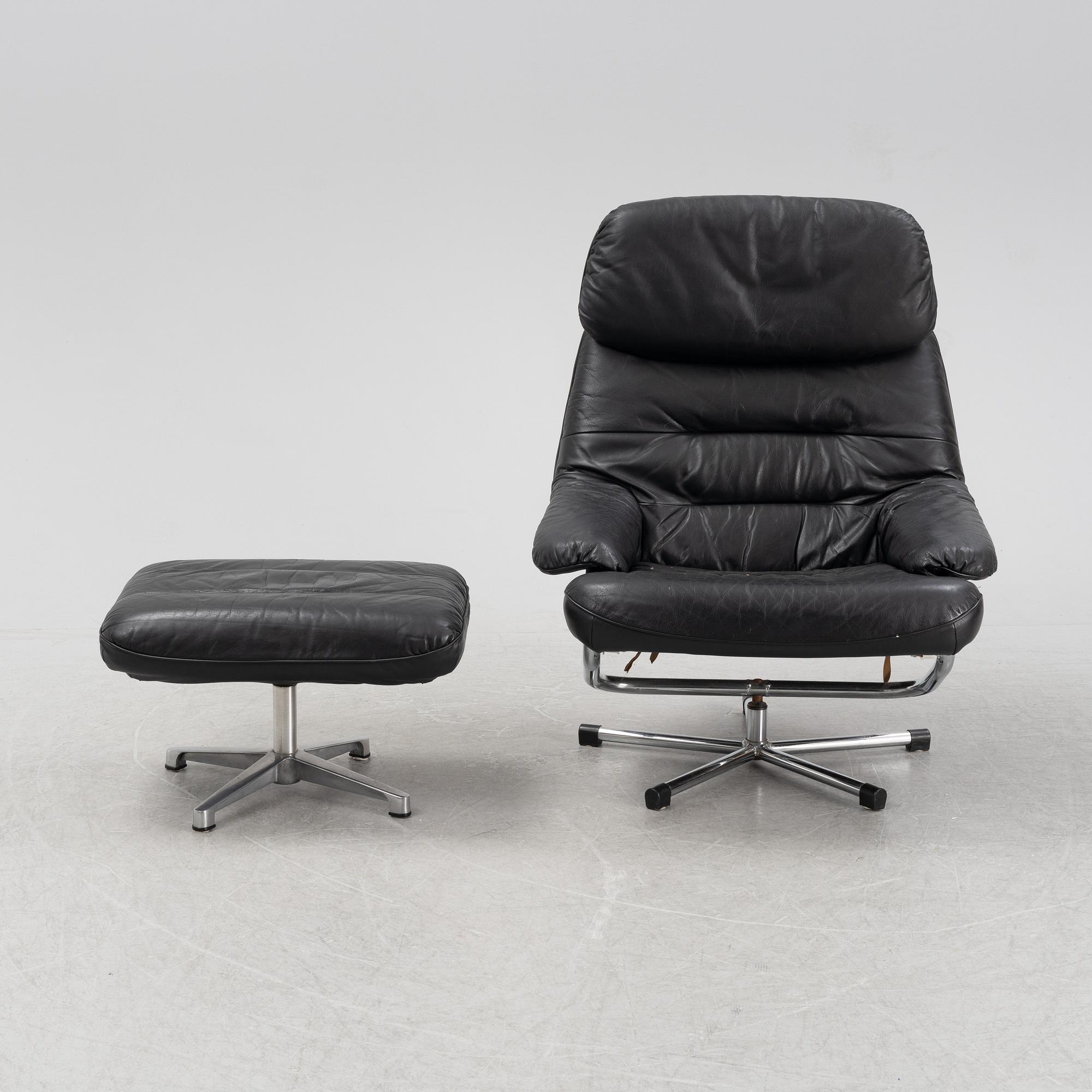 A leather and chrome lounge chair and foot stool, 1970's/80's.