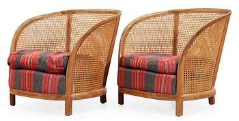 A pair of Oscar Nilsson beech and rattan arm chairs.